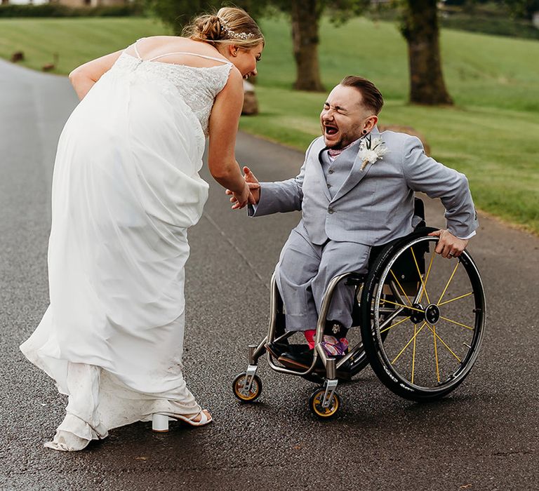 bride-in-traditional-wedding-dress-with-groom-in-wheelchair-in-light-blue-wedding-suit