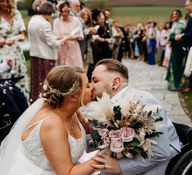 bride-kisses-groom-in-wheelchair-after-confetti-exit