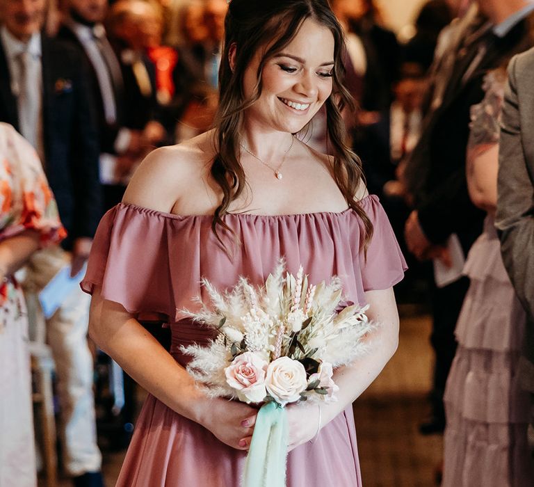 bridesmaid-in-dusty-pink-off-the-shoulder-bridesmaid-dress-with-pampas-grass-bouquet