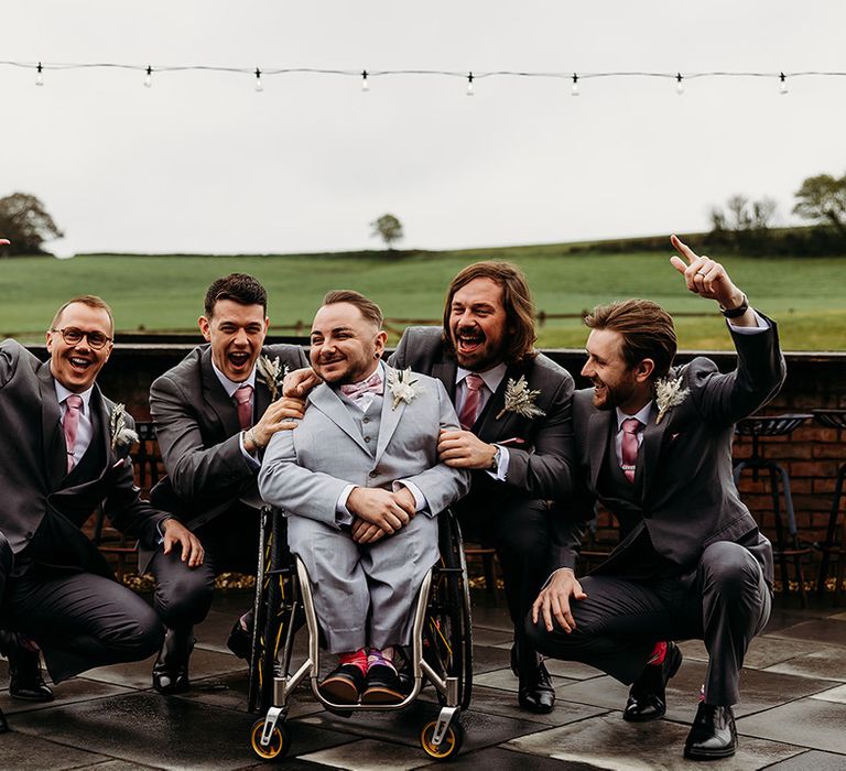 groom-in-light-grey-wedding-suit-with-groomsmen-in-dark-grey-suit.