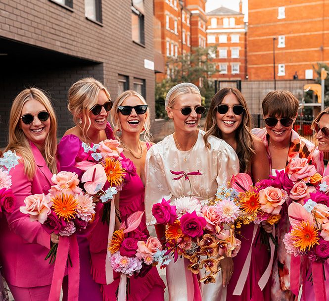 bridal-party-wearing-pink-bridesmaid-dresses-and-suits