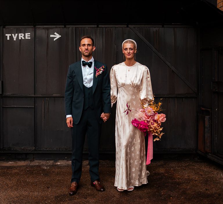 bride-in-long-sleeve-satin-wedding-dress-with-groom-in-black-tie