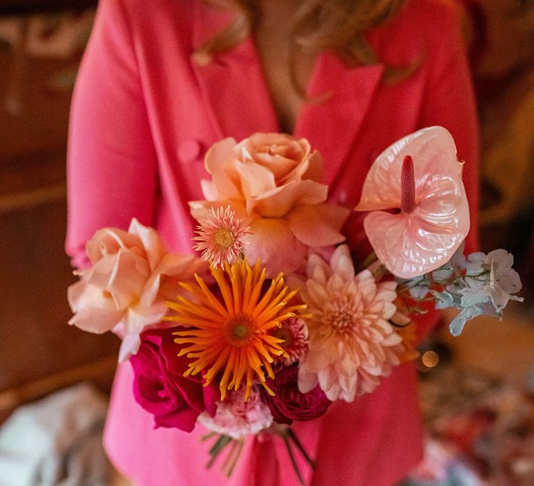 bridesmaid-in-pink-suit-holding-pink-wedding-bouquet