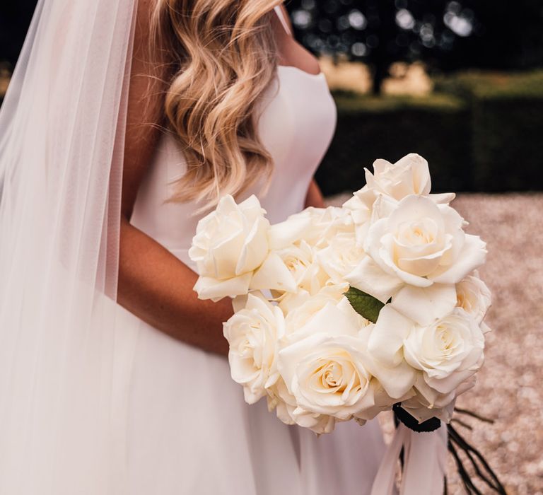 bride-holding-white-rose-long-stem-wedding-bouquet