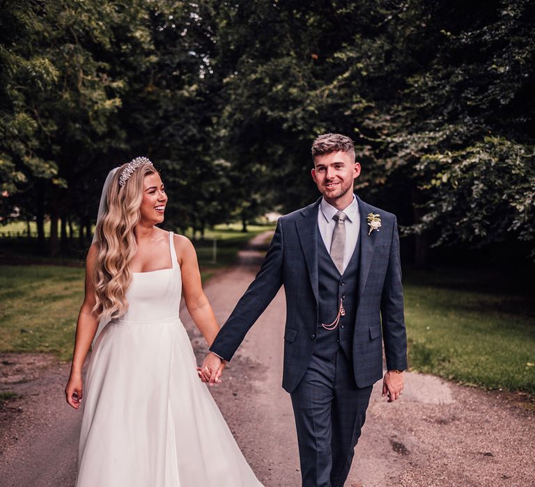 bride-in-suzanne-neville-wedding-dress-with-groom-in-navy-suit