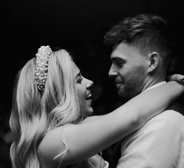 bride-wearing-pearl-wedding-headband-smiling-at-groom