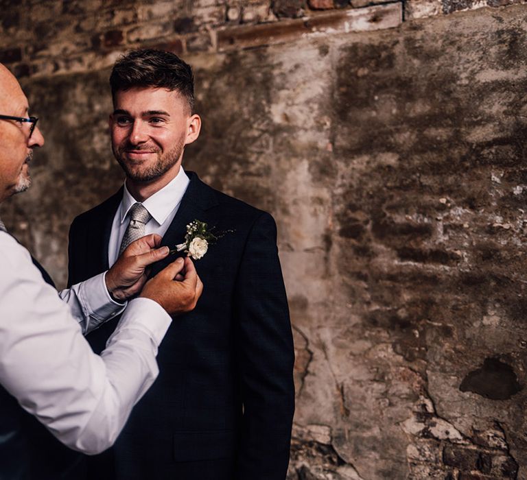 groom-gets-buttonhole-fixed-to-suit