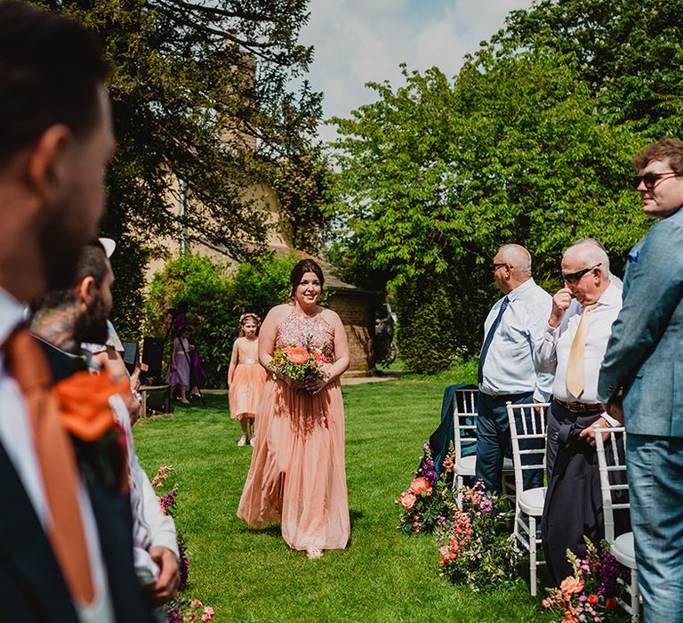 bridesmaids-in-peach-bridesmaid-dresses-walking-down-the-aisle