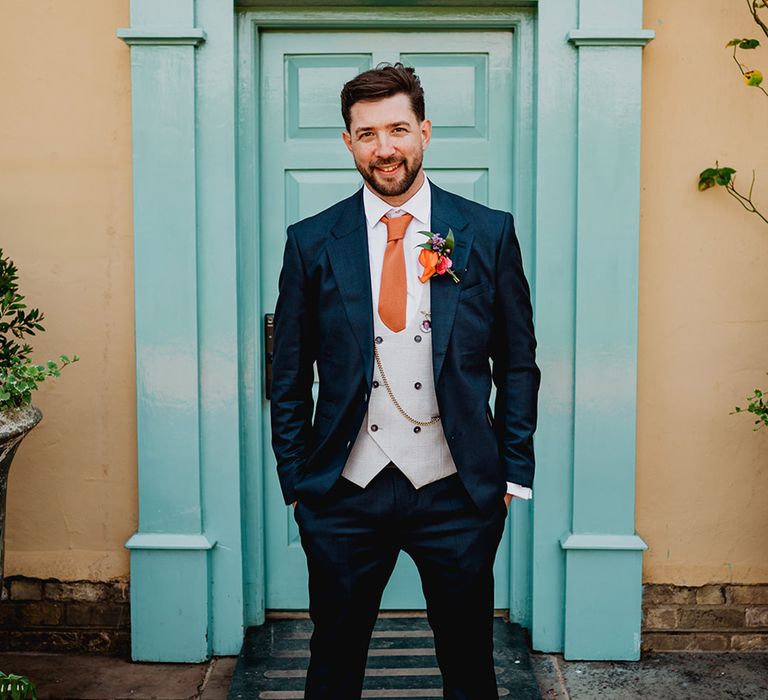 groom-in-three-piece-wedding-suit-with-navy-jacket-and-grey-waistcoat