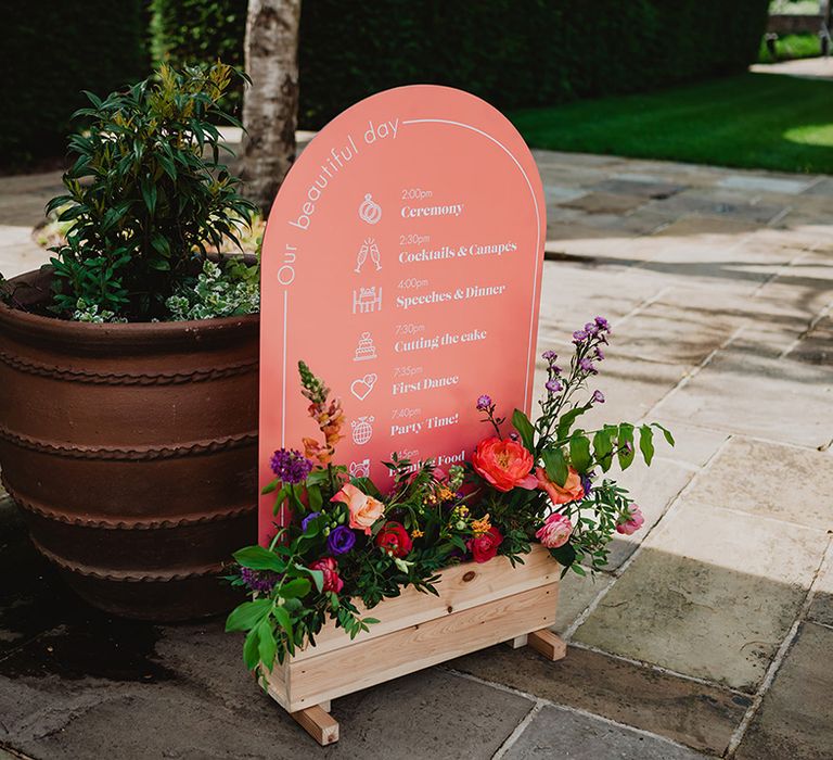 pink-arched-wedding-order-of-the-day-wedding-sign