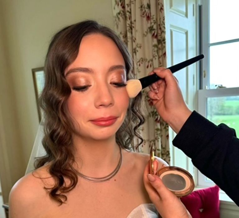 bride-getting-makeup-done-for-wedding-with-luminous-skin