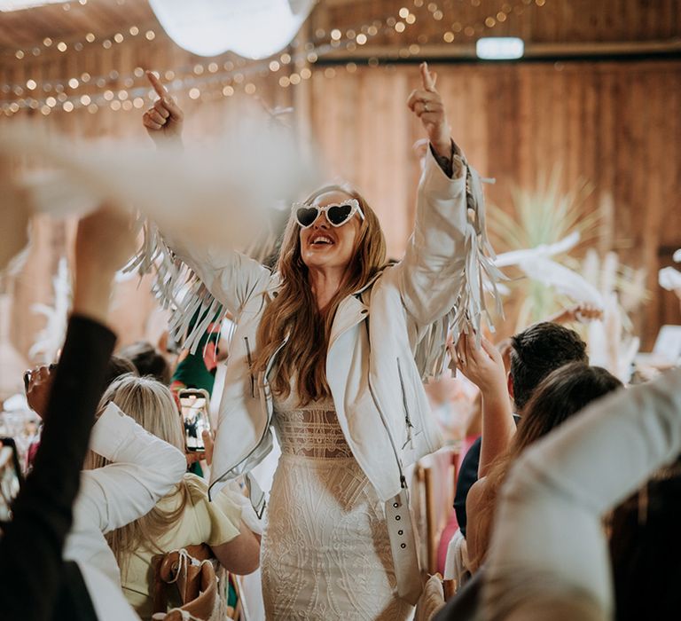 bride-wearing-boho-wedding-dress-with-tassel-leather-jacket-and-sunglasses