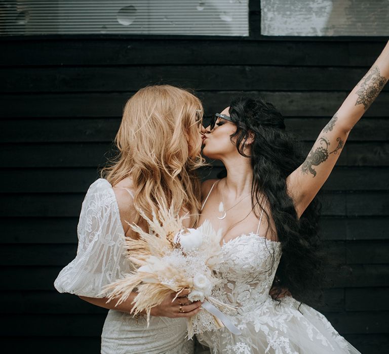 two-brides-share-a-kiss-with-dried-flower-bouquet