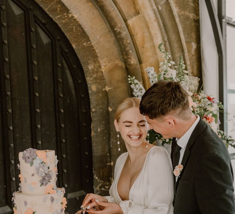 bride-and-groom-cut-their-flower-iced-wedding-cake