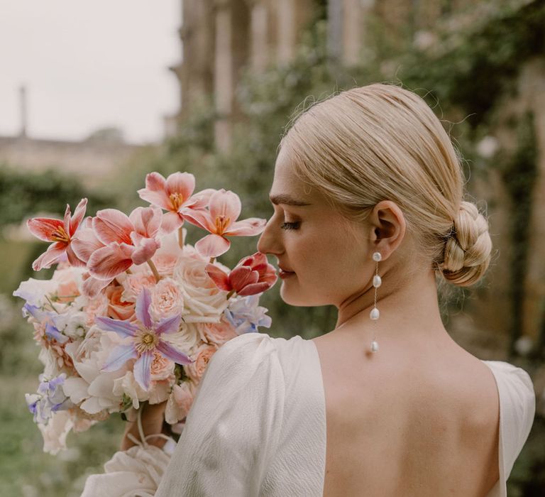 bride-in-open-back-wedding-dress-with-pearl-earrings-and-chic-updo