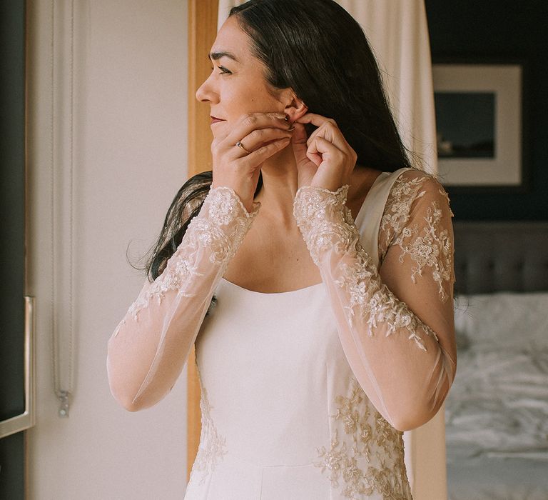 bride-puts-on-wedding-earrings