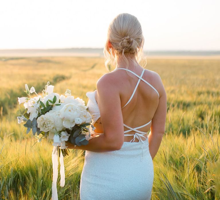 bride-in-halter-neck-back-with-white-peony-wedding-bouquet