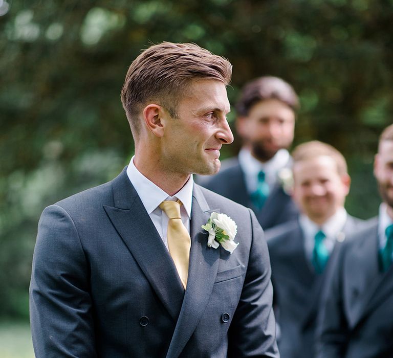 groom-in-navy-suit-with-yellow-tie-and-white-rose-buttonhole