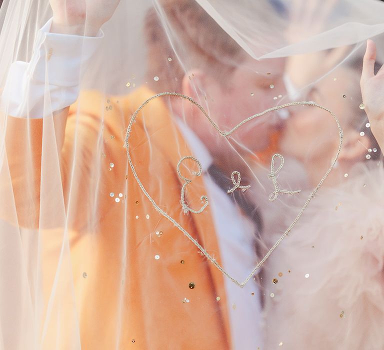 bride-and-groom-kiss-under-embroidered-wedding-veil