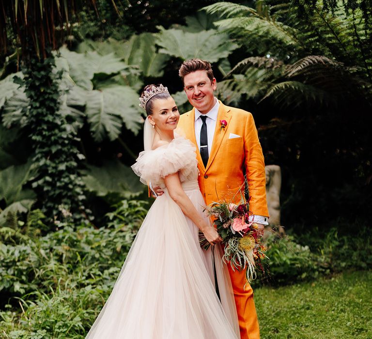 bride-wearing-embroiderd-wedding-veil-with-groom-in-yellow-suit