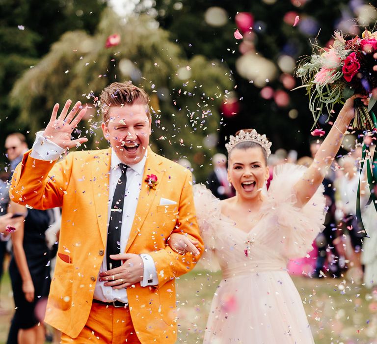 groom-in-mustard-yellow-suit-with-bride-in-pink-princess-wedding-dress