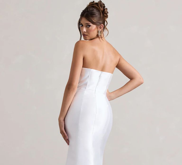 Back view of budget friendly satin wedding dress with asymmetric neckline and bold fishtail skirt from Club L London