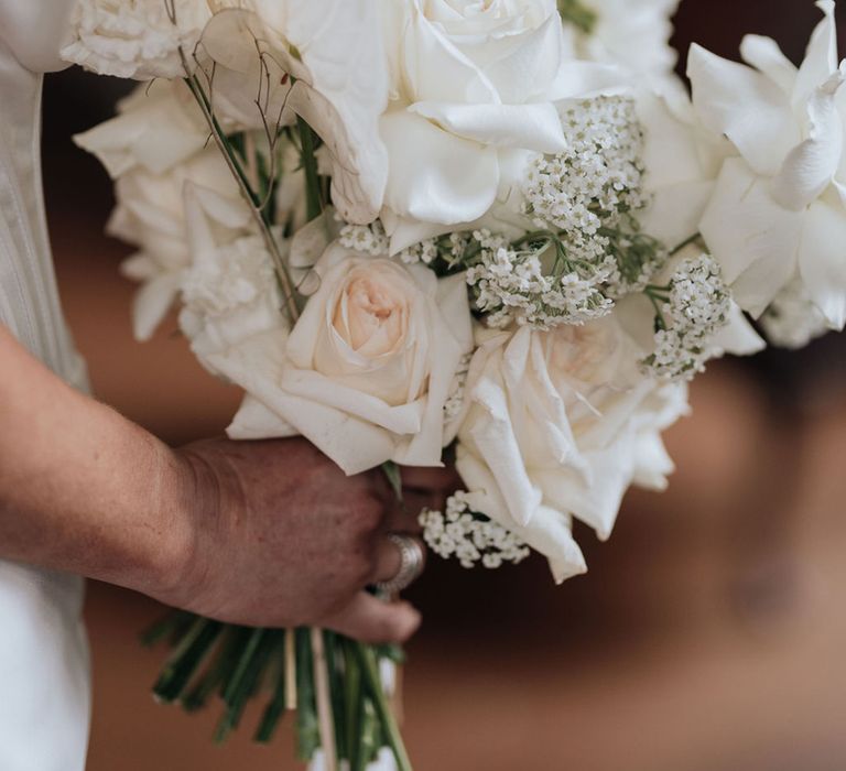 bride-carrying-white-wedding-bouquet-with-anthuriums-and-roses