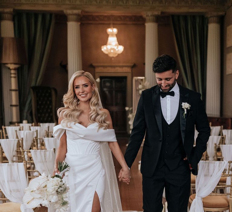 bride-in-off-the-shoulder-wedding-dress-and-groom-in-black-tuxedo