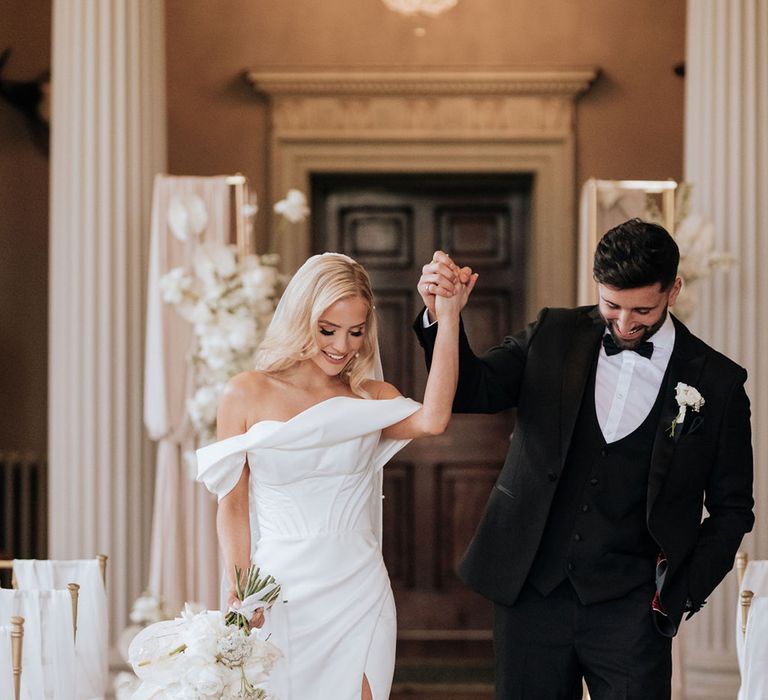 bride-in-off-the-shoulder-wedding-dress-with-groom-in-black-tuxedo