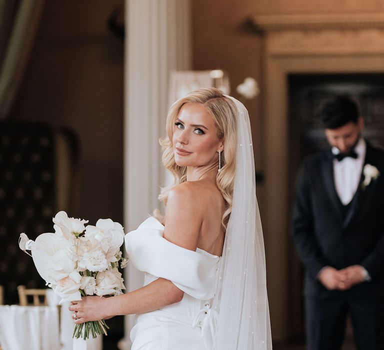 bride-in-off-the-shoulder-wedding-dress-with-white-rose-bouquet