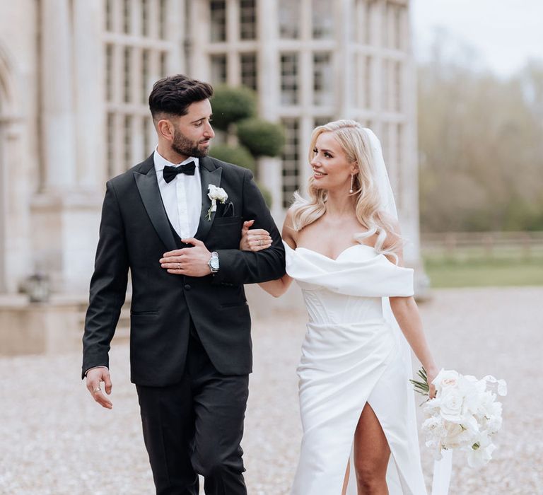 groom-in-black-tuxedo-with-bride-in-front-slit-wedding-dress