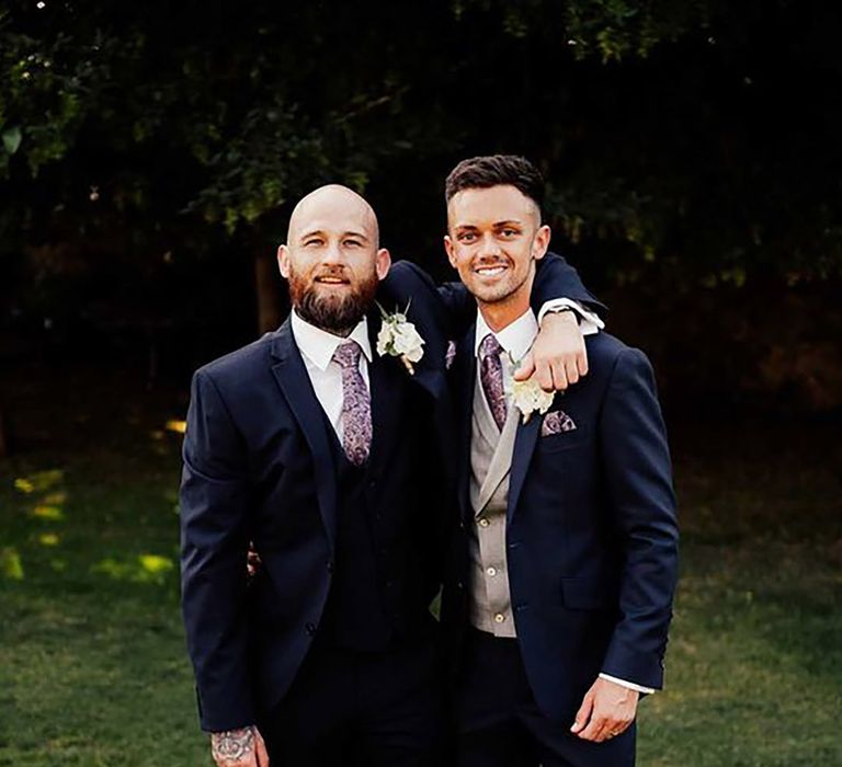 groom and best man wearing matching navy suits, plus groom wearing grey waistcoat