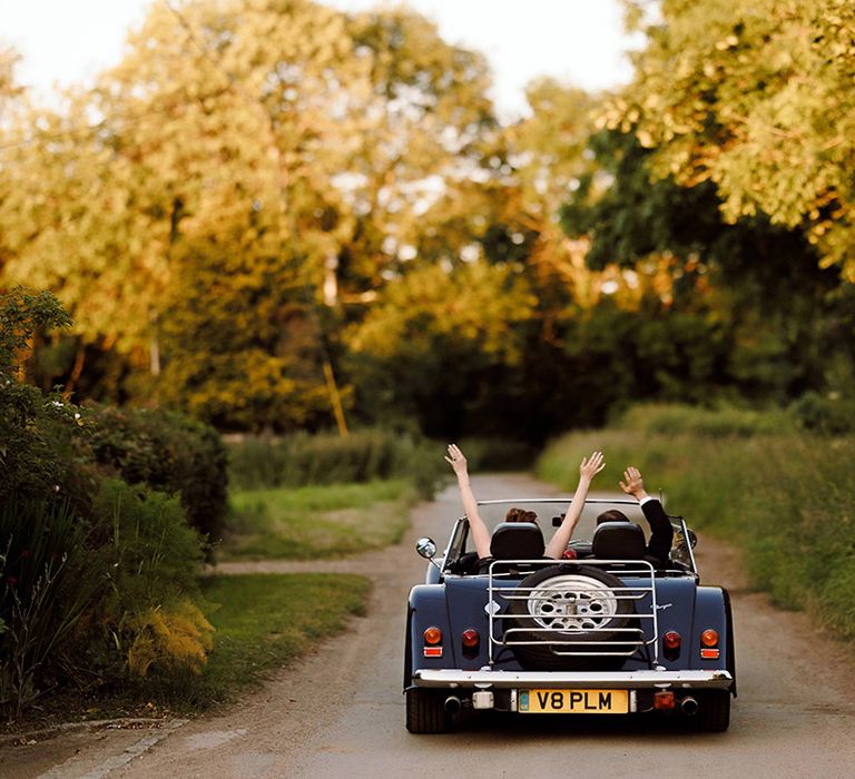 bride-and-groom-ride-off-together-in-their-classic-wedding-car