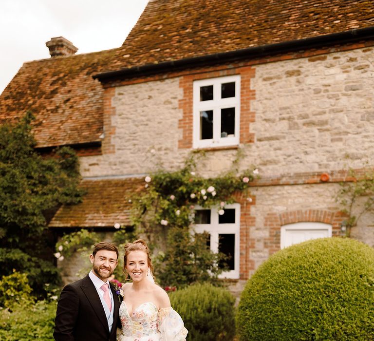 bride-in-pastel-flower-wedding-dress-with-groom-in-morning-suit