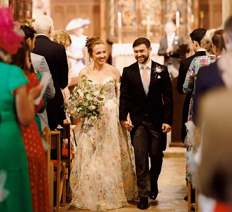 morning-suit-for-groom-walking-back-down-the-aisle-with-bride-in-pastel-wedding-dress