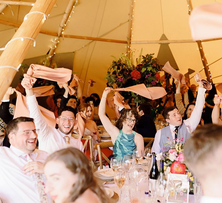 wedding-guests-wave-napkins-at-wedding-breakfast