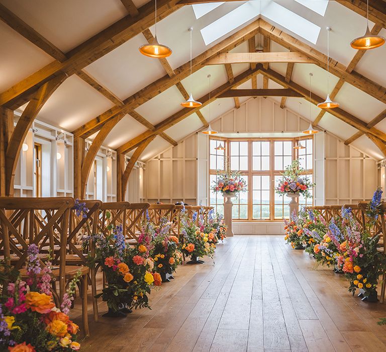 barn-wedding-venue-with-colourful-aisle-flowers