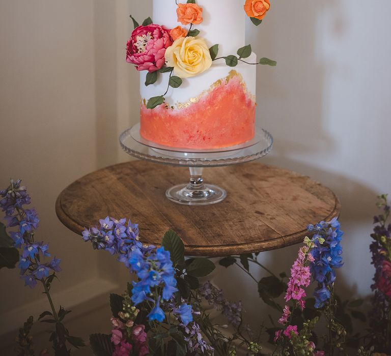 coral-and-white-wedding-cake-with-gold-flakes-and-handmade-flowers