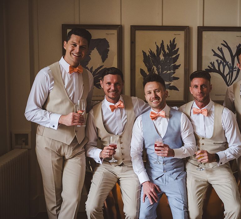 groom-and-groomsmen-group-photo-in-beige-suits-and-groom-in-light-blue-suit