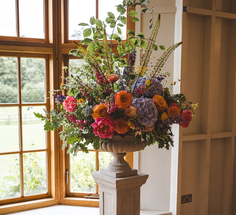 pink-purple-blue-and-orange-wedding-flower-arrangement-in-urn