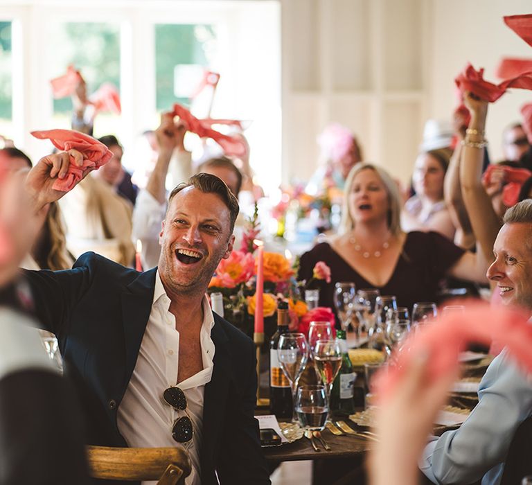 wedding-guests-wave-pink-napkins-to-greet-the-grooms