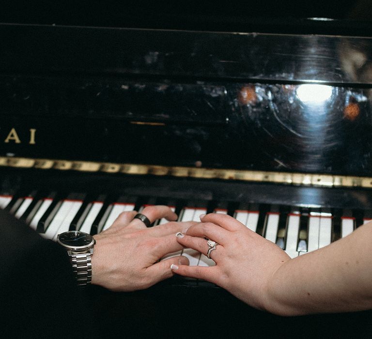 bride-and-groom-play-piano-showing-off-wedding-rings