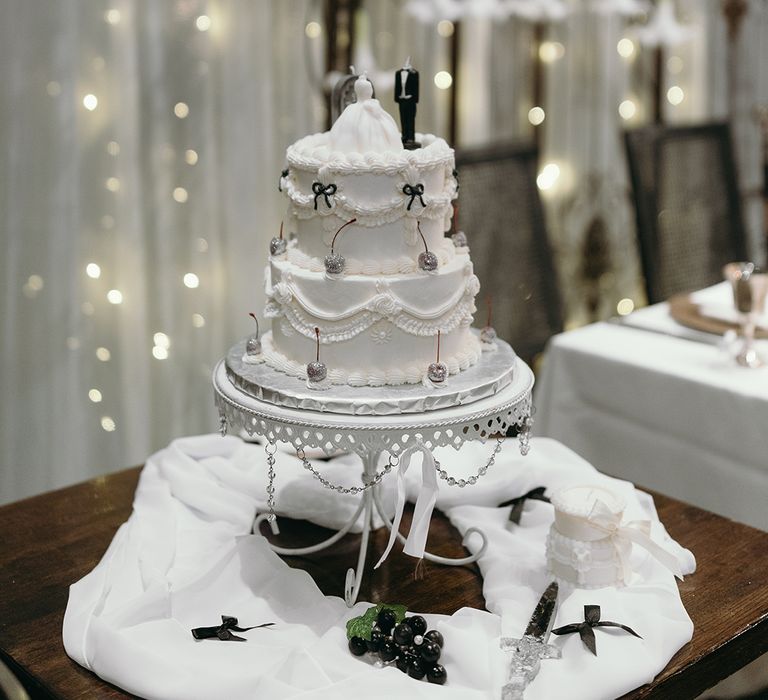 three-tier-white-retro-wedding-cake-with-bows-and-figurine-cake-toppers