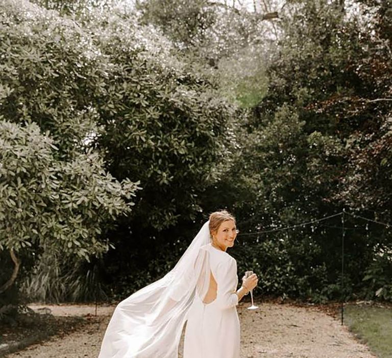 bride wearing a backless long sleeve bespoke wedding dress 