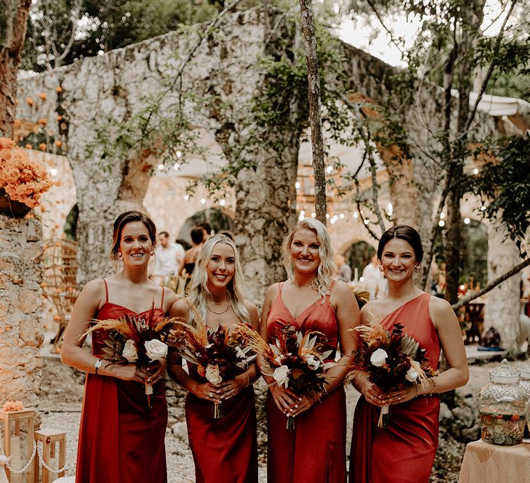 bridal-party-wearing-orange-satin-bridesmaid-dresses-with-boho-bouquets