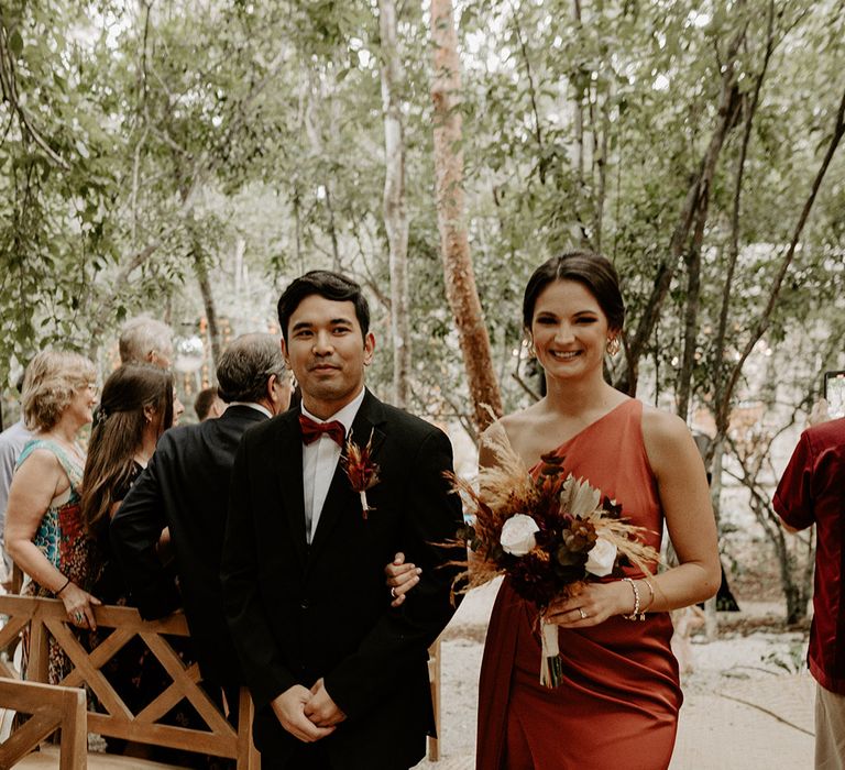 groomsman-and-bridesmaid-in-orange-satin-dress