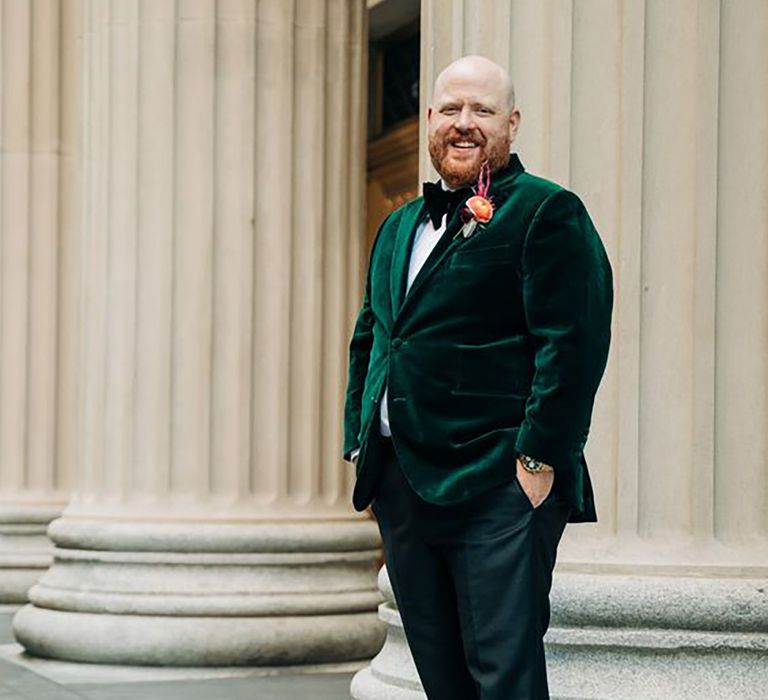 groom wearing dark green velvet suit jacket on wedding day