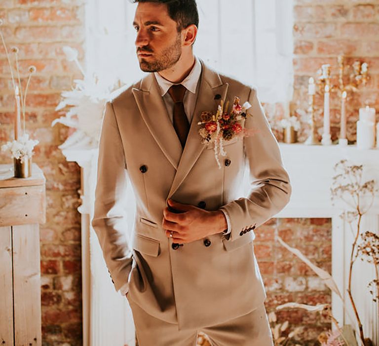 groom wearing double breasted cream wedding suit