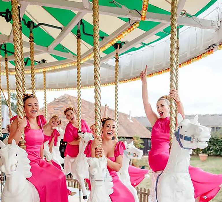 bridesmaids wearing hot pink bridesmaid dresses on carousel ride