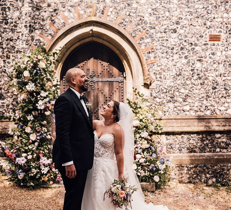 bride-gazes-up-at-groom-at-church-wedding-in-hampshire